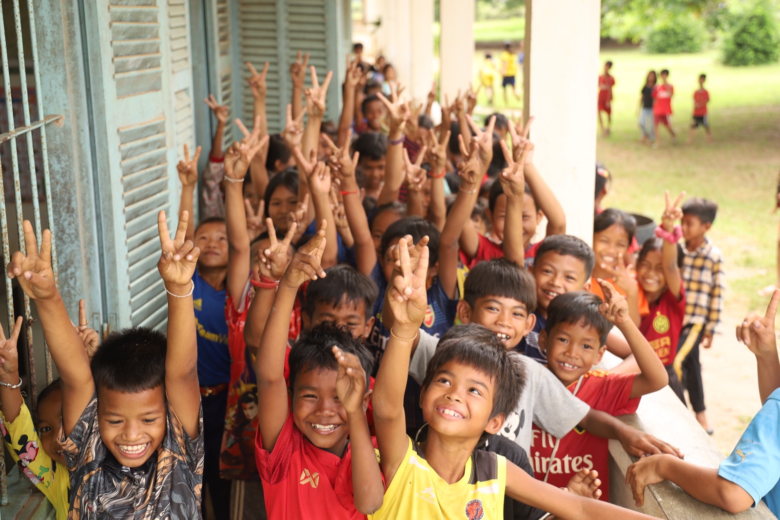 Children raising their hands at a school outreach, Cambodia, 2024