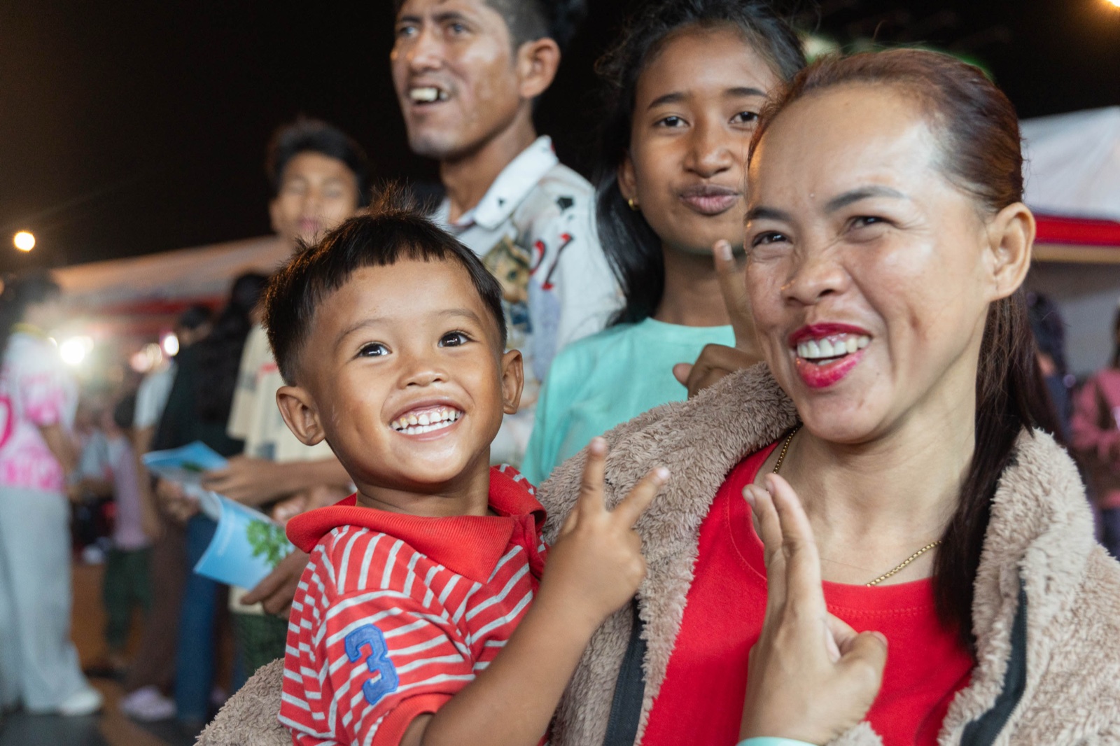 A mother and son smiling in the crusade crowd, Kandal, 2026
