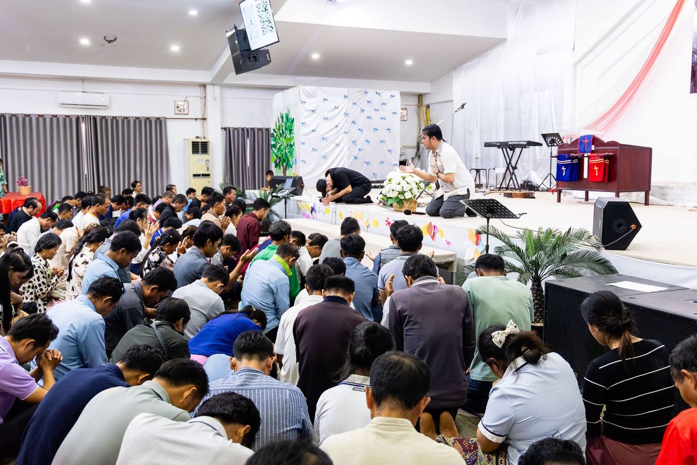 Believers kneeling in prayer at a Jesus Camp in Laos